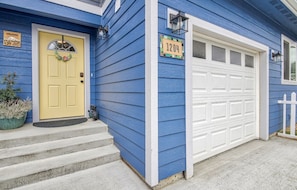 Une maison avec une porte jaune, un garage et une boîte aux lettres.