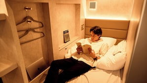 Une chambre d’hôtel avec un lit, un ordinateur portable et un livre.