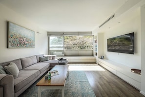 A modern living room with a sofa, coffee table, and artwork on the walls.