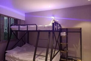 Dormitorio con literas, una mesita de noche y un espejo.