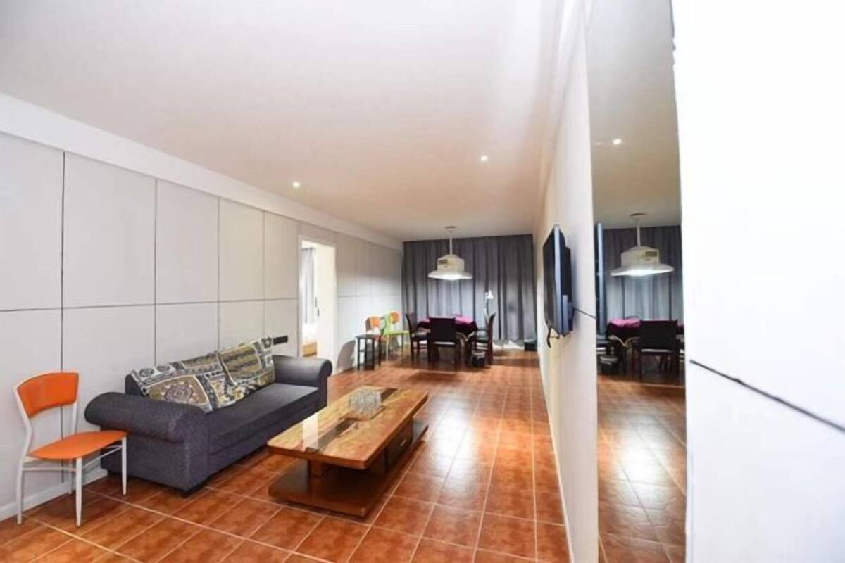 Una sala de estar moderna con un sofá, una mesa de centro y un comedor con sillas y una mesa.