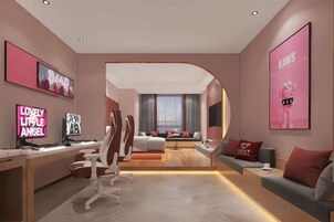 Una habitación de hotel moderna con una pared curva, un escritorio con computadora, un sofá cómodo y un ventanal grande.