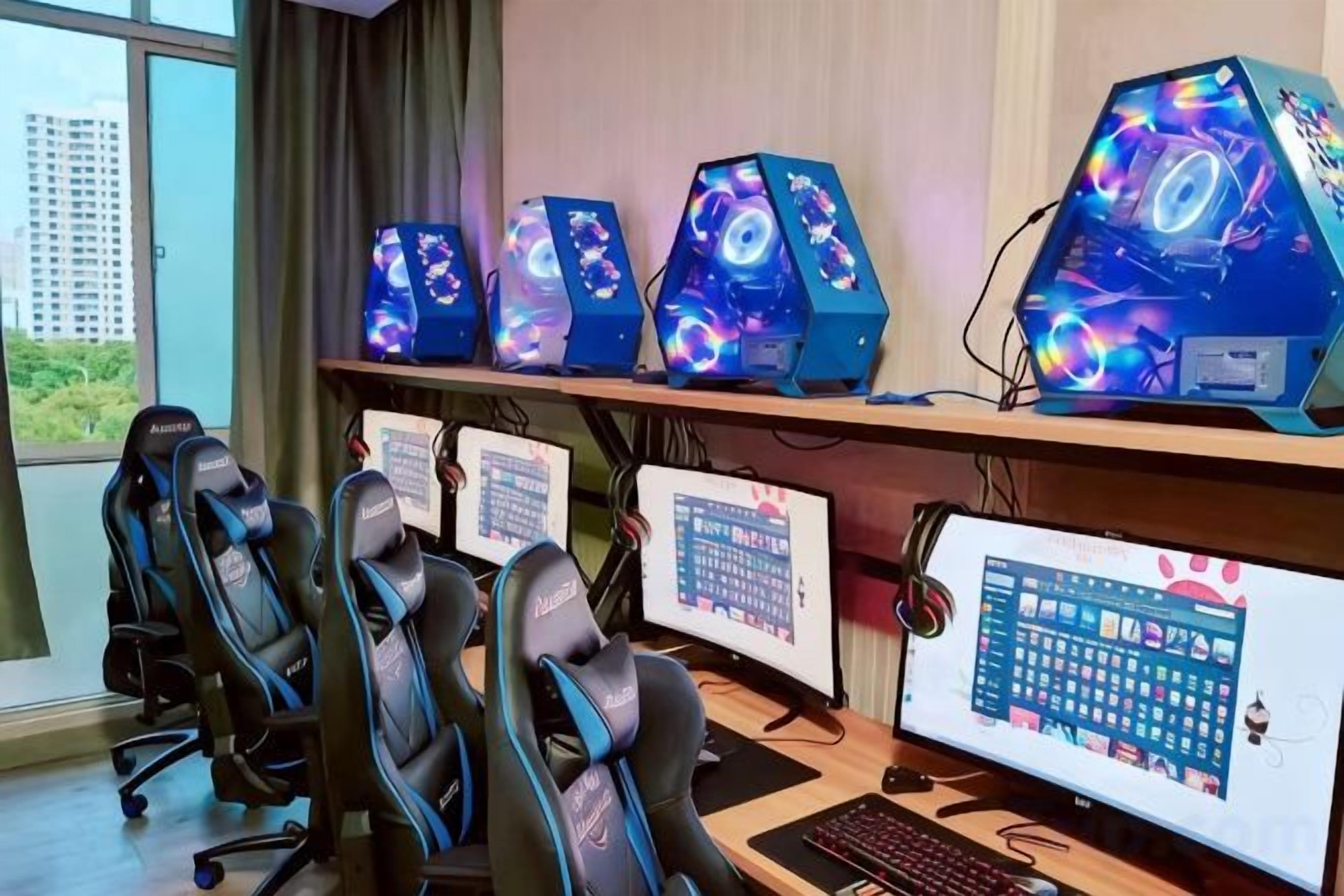 Configuración para videojuegos con múltiples monitores, sillas gamer y un escritorio.
