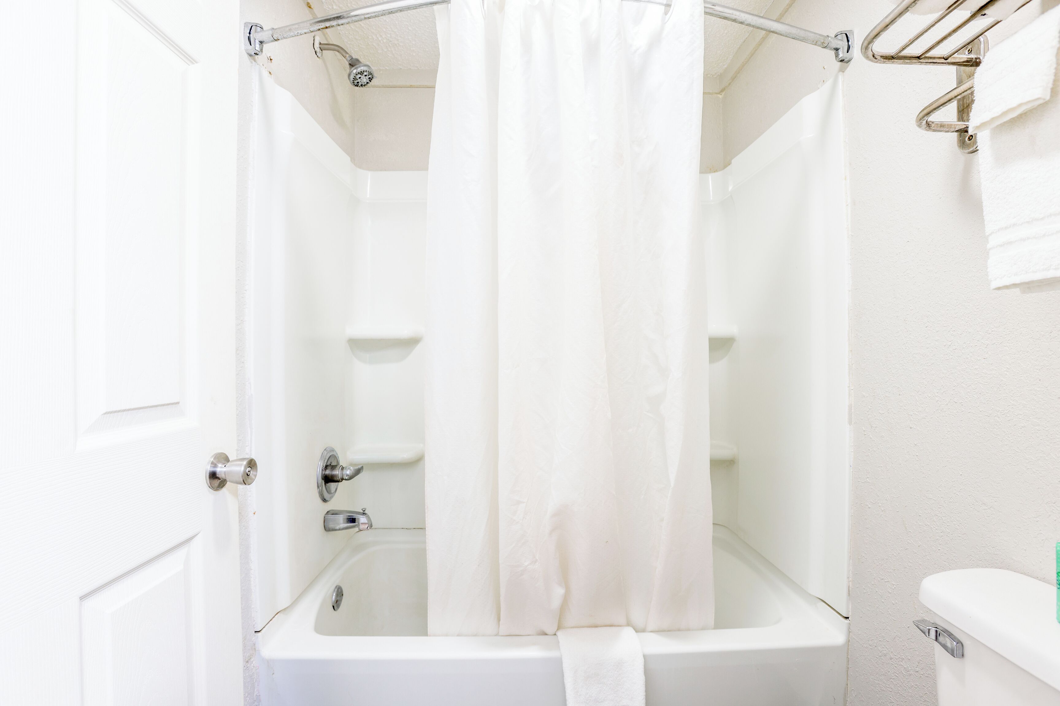 Une salle de bain avec une baignoire, un rideau de douche et un porte-serviettes.
