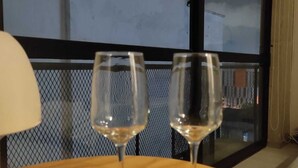 Duas taças de vinho vazias sobre uma mesa, com vista para uma janela.