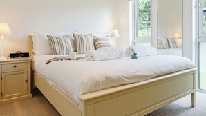 Un dormitorio con cama, mesitas de noche, lámparas y ventana con vistas.