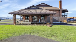 A brick building with a covered porch and a chimney. - Bridgeview Inn Chicago Area (Bridgeview)