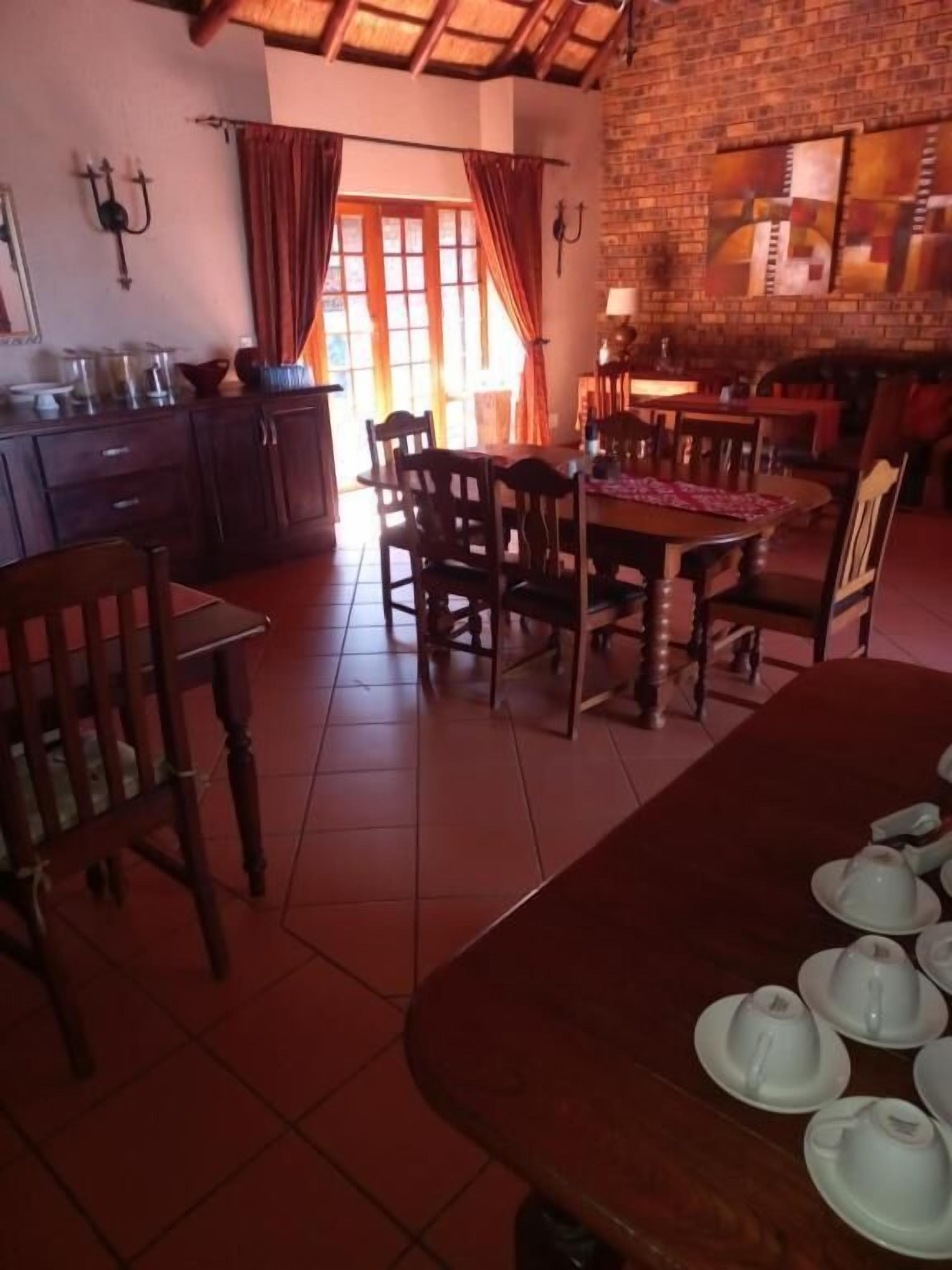 Comedor con pared de ladrillo, mobiliario de madera y piso de baldosas.