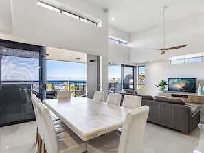 Enjoy a spacious dining area with a comfortable seating area leading to a balcony with ocean views.