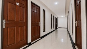 Un pasillo con puertas de madera, cada una con un número, que conduce a habitaciones individuales.