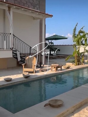 A pool area with a staircase, lounge chairs, and a covered seating area. - Cunda Panjur Villa (Ayvalik)