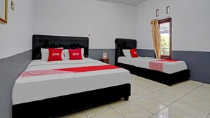 Two single beds with black frames and white bedding, each with a red pillow and a red blanket. - OYO 90405 Penginapan Sasti KuninganNearTaman Cirendang (Cilimus)