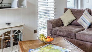 A living room with a brown suitcase, a fruit bowl, and a map on a coffee table.