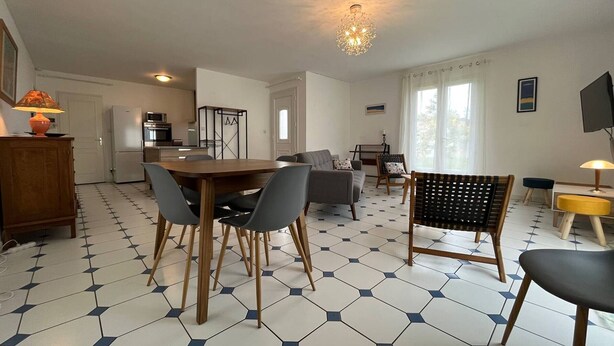 Ein modernes Wohnzimmer mit Esstisch, Sofas und einem Fernseher.