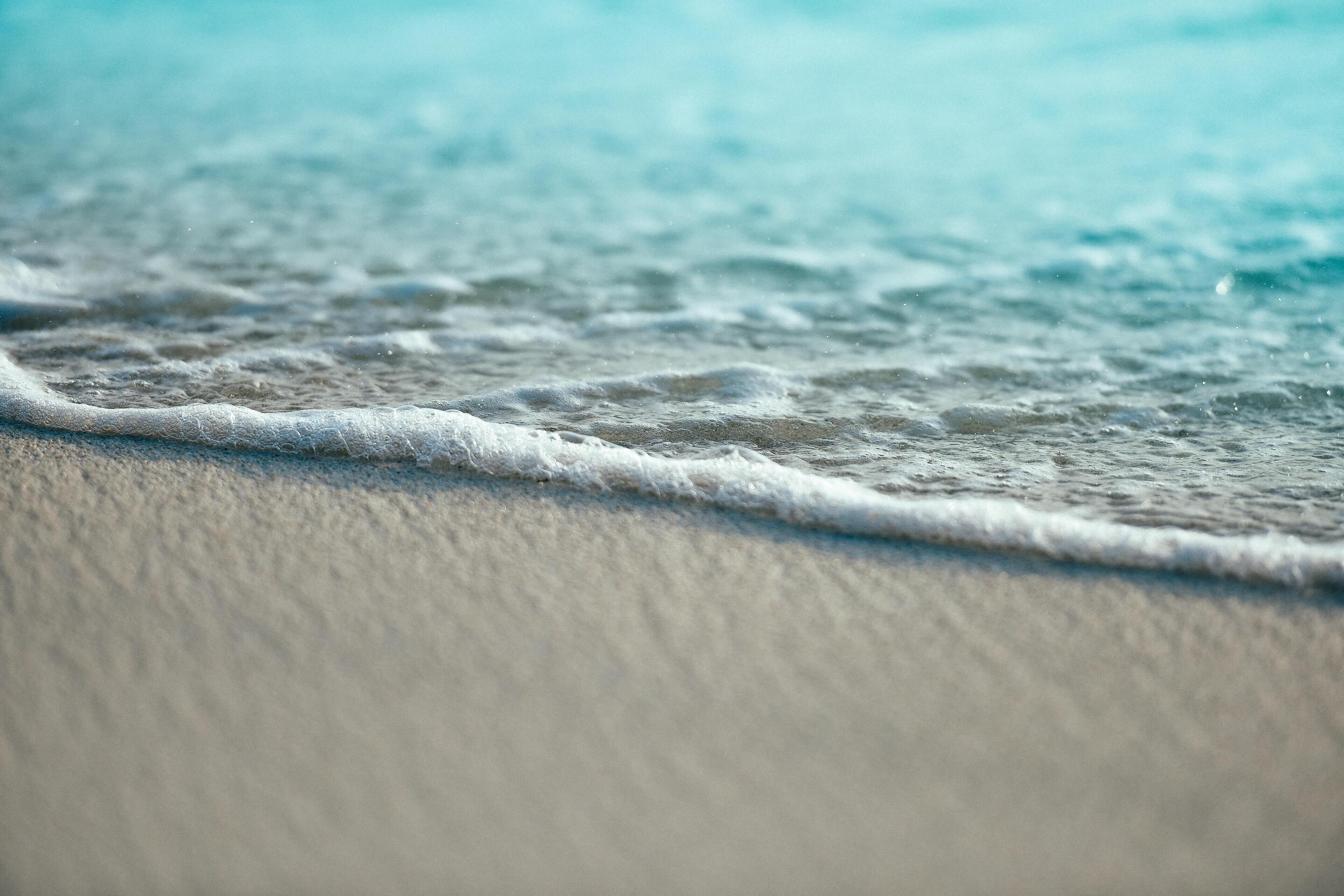 Primer plano de una playa arenosa con olas suaves.