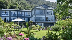 A two-story building with a sign reading "Serenity Ocean Lodge." - Serenity Ocean Lodge (Wilderness)