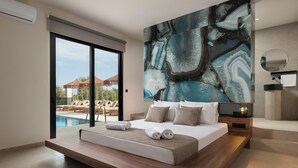 A modern bedroom with a large bed, a view of the pool, and a marble wall. - Mirena Luxury Living - Casa Di Ria (Αφάντου)