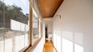 A narrow hallway with wooden flooring and large windows on one side. - Ca Se Predine by Rentallorca (Alcúdia)