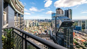 Um edifício alto com fachada de vidro moderna, vista de um horizonte urbano com diversos edifícios e céu claro.