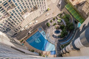 Un edificio de gran altura con un patio central que incluye una fuente y una piscina con diseños.