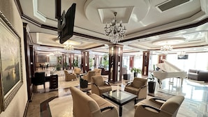 A spacious lobby with a grand piano, comfortable seating, and elegant chandeliers. - Modern Hotel - Baku (Baku)