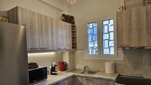 Une cuisine moderne avec des meubles en bois, un évier en acier inoxydable, un four Bosch et un four à micro-ondes.