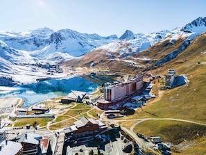 A mountainous landscape with a large body of water, a ski resort, and several buildings including a hotel.