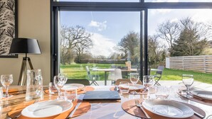 Mesa de comedor para cuatro con vista al exterior a través de amplios ventanales.