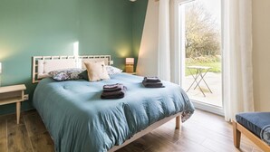 Un dormitorio con cama, mesitas de noche y vistas al exterior.