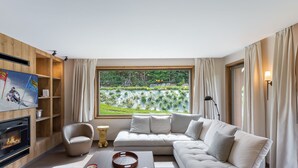 Un salon moderne avec une grande fenêtre, une cheminée et un canapé.