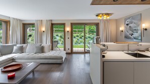 Un salon moderne comprenant un canapé, une table basse et un coin cuisine avec un évier et un grille-pain.