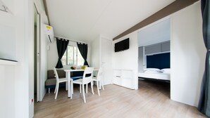 Une petite pièce comprenant un lit, une petite table et une chaise.