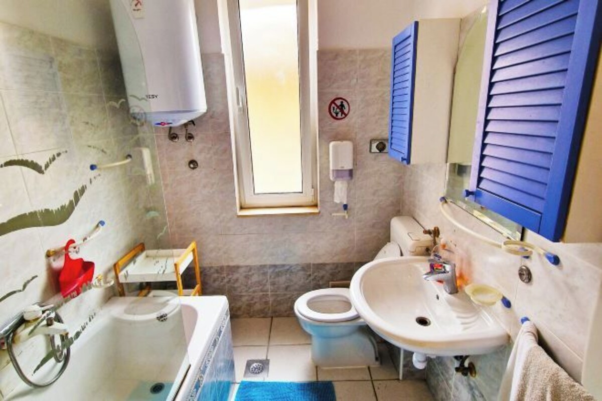 Een badkamer met een bad, toilet en wastafel.