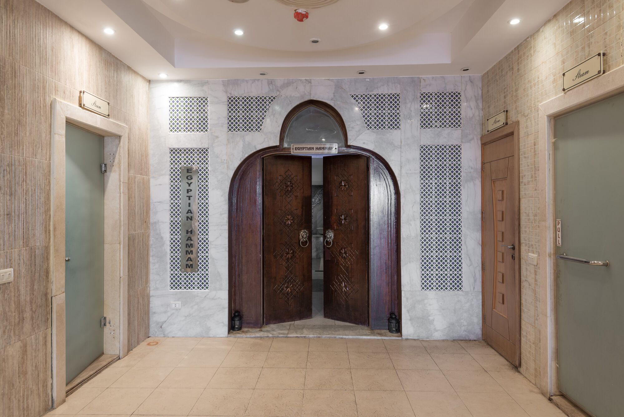 A hallway with a central double door labeled "EGYPTIAN HAMMAM" and two smaller doors on either side.