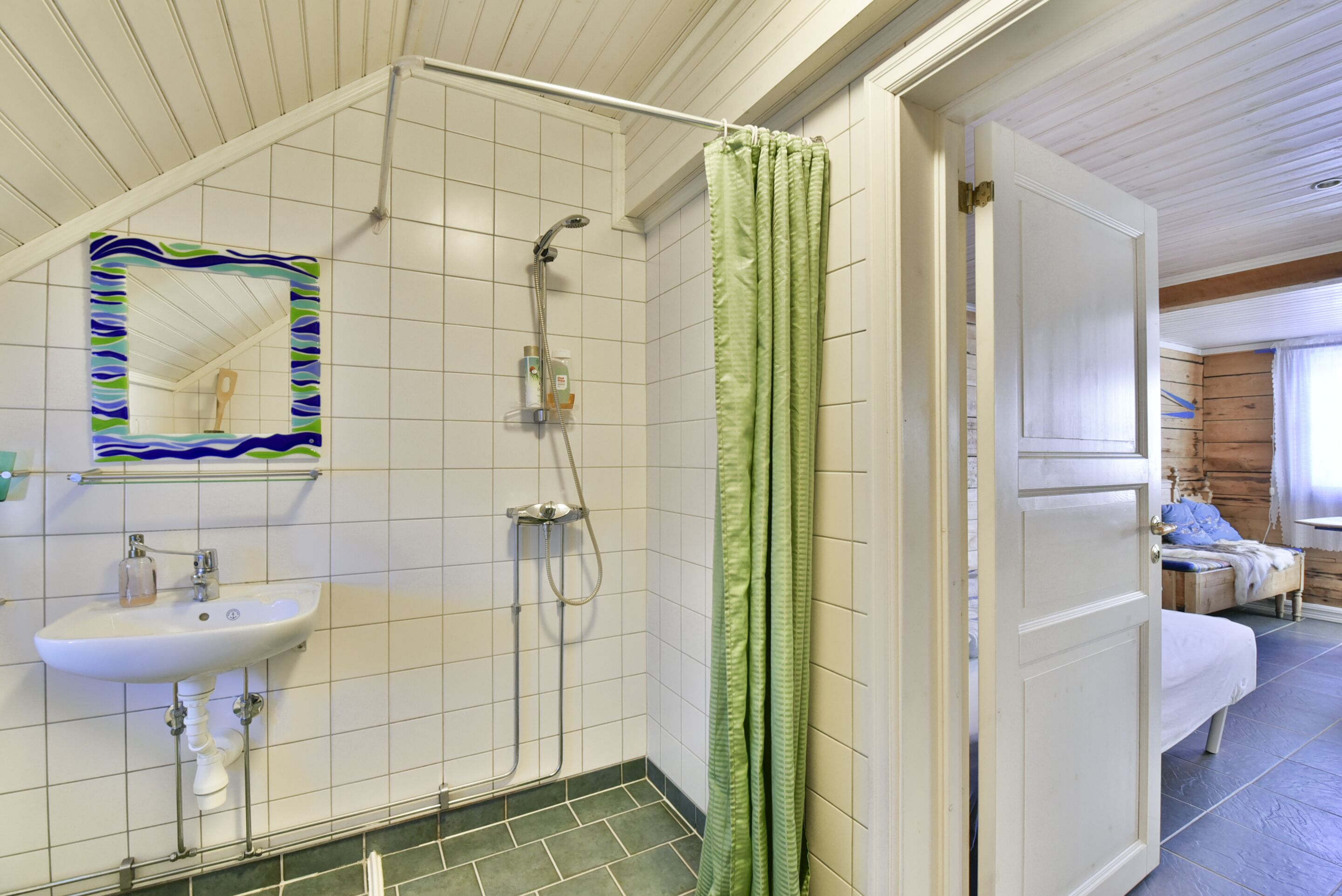 A bathroom with a shower, a sink, and a mirror.