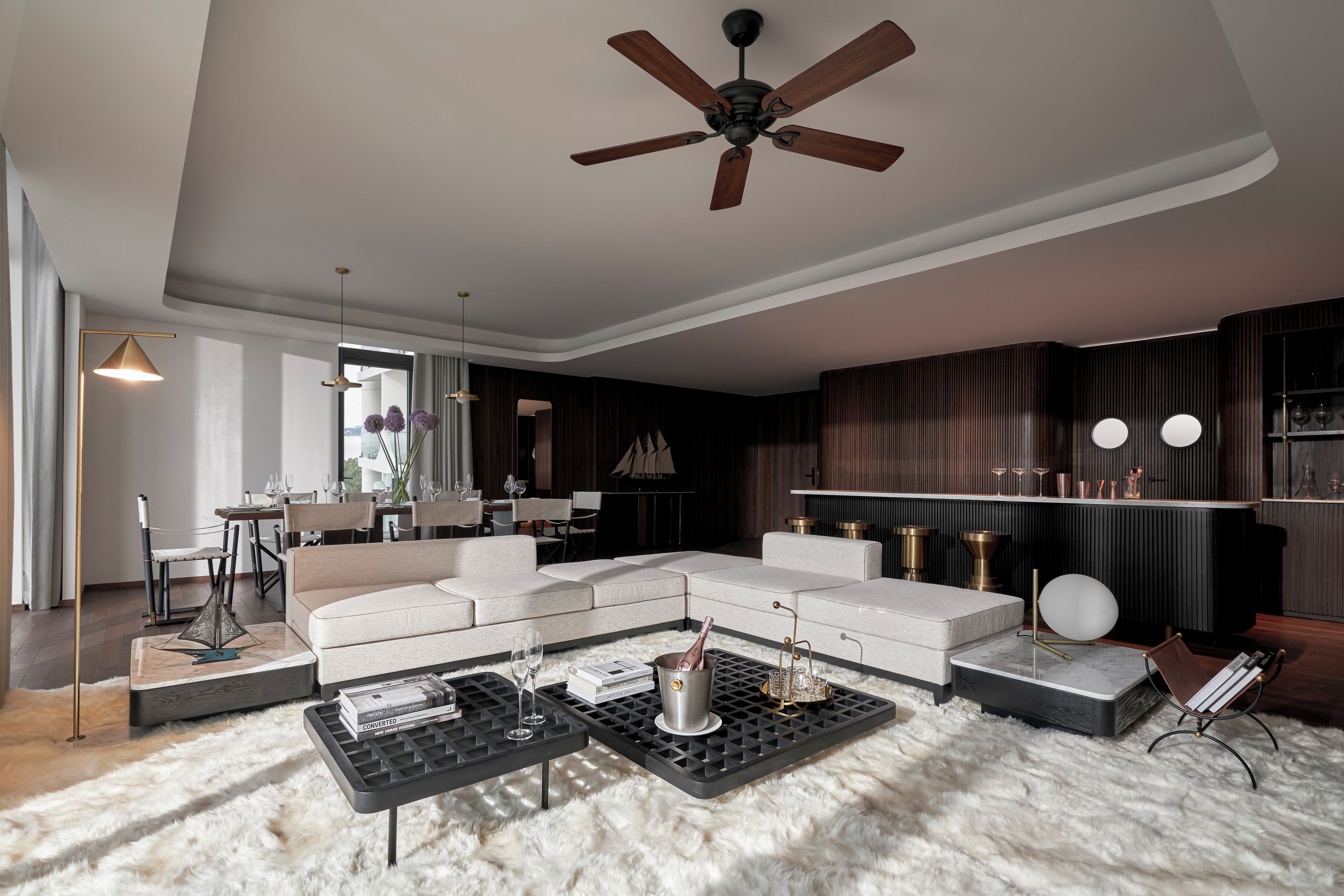 Una sala moderna con un sofá modular, una mesa de centro y un ventilador de techo.