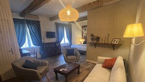 Una sala de estar con un sofá, sillones, una mesa de centro y una lámpara colgante.