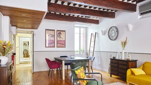 Un comedor con una mesa y sillas de madera, un sofá amarillo y una chimenea.