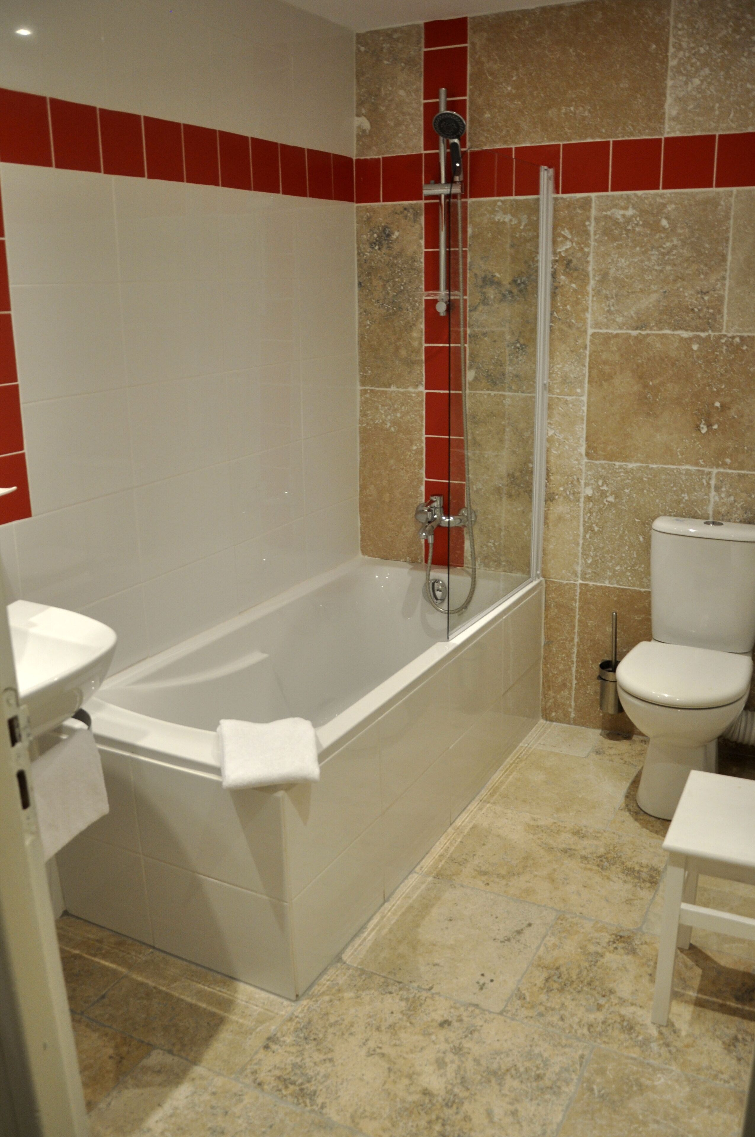 A bathroom with a bathtub, toilet, and shower.