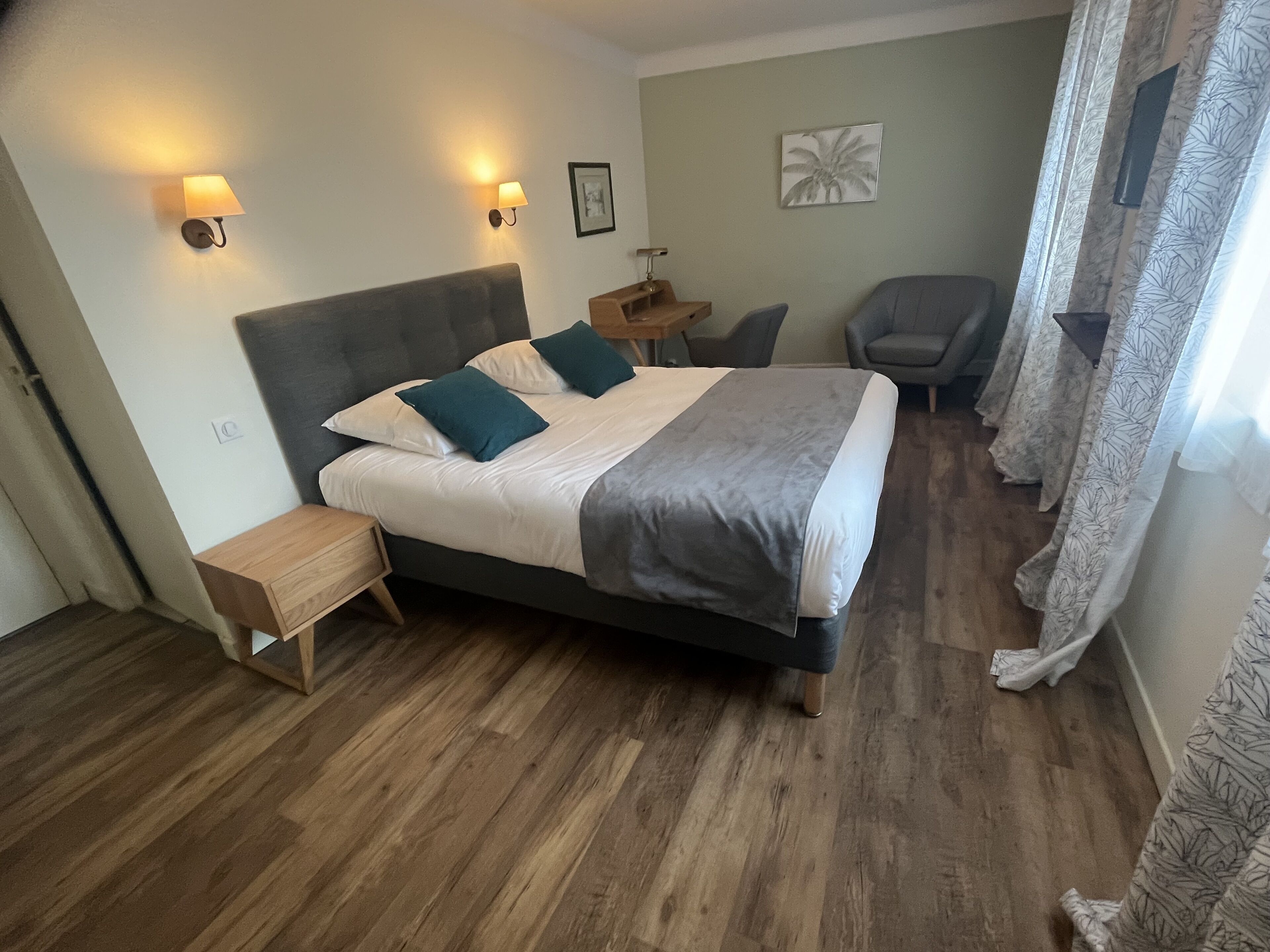 A bedroom with a bed, nightstands, a chair, and a small table.
