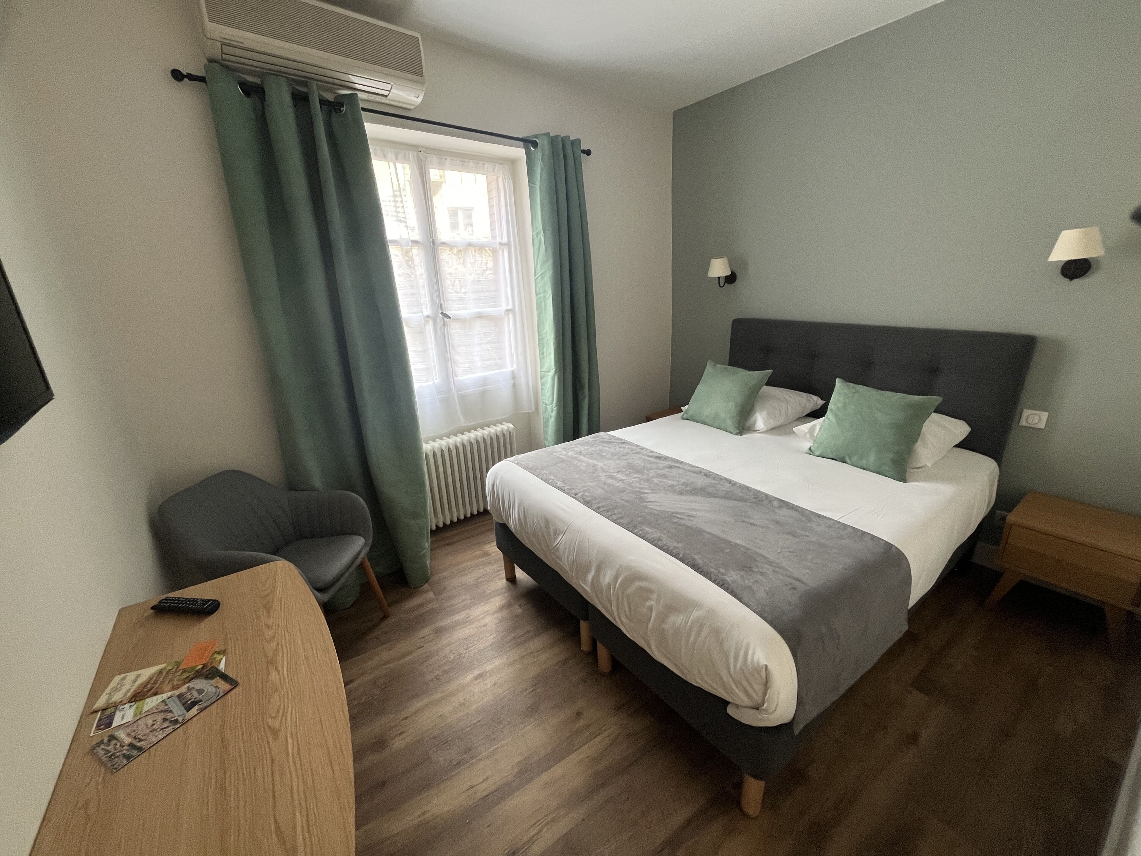 A neatly arranged bedroom with a bed, a desk, and a chair.