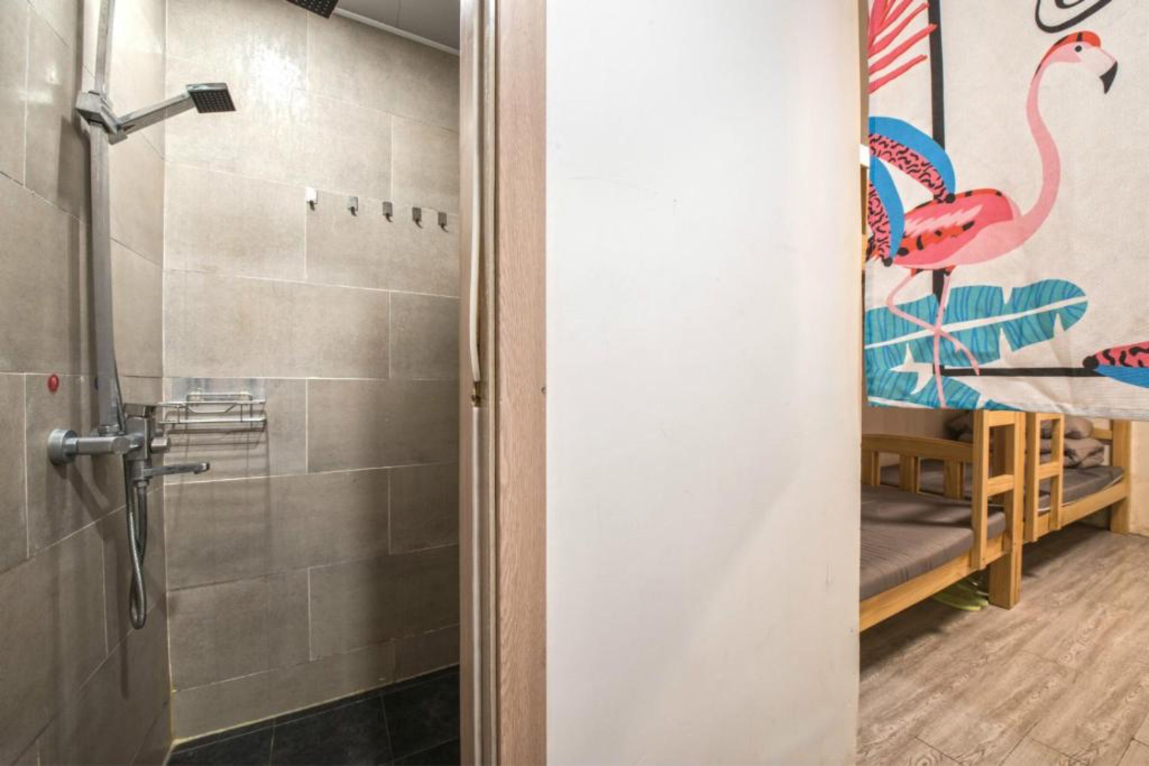 A shower with a handheld showerhead and a wall-mounted faucet.