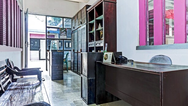 A reception area with a desk, chairs, and a large window. - OYO 90696 Tobana House Bintaro (Jakarta)