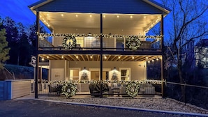 Une maison à deux étages dotée d’un balcon, décoré de guirlandes lumineuses et de couronnes.