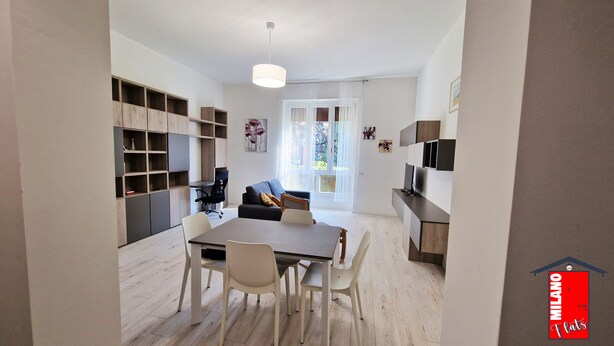 Un appartement moderne comprenant un coin repas, un salon avec un canapé et une cuisine.