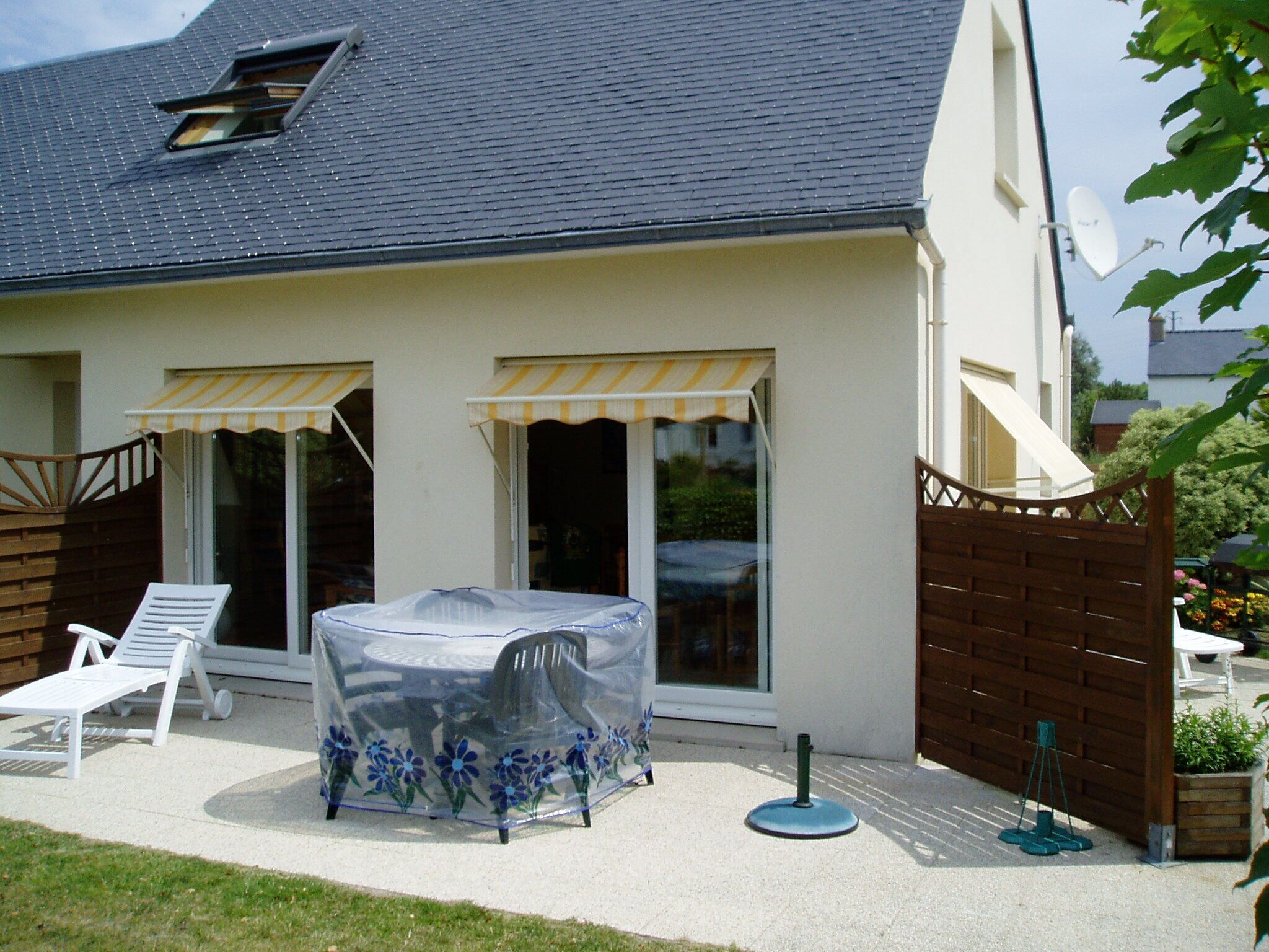 A house with a covered patio area, a sliding glass door, and a satellite dish.