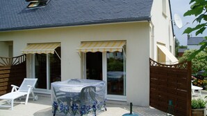 A house with a covered patio area, a sliding glass door, and a satellite dish. - Propriété (Saint-Pierre-Quiberon)