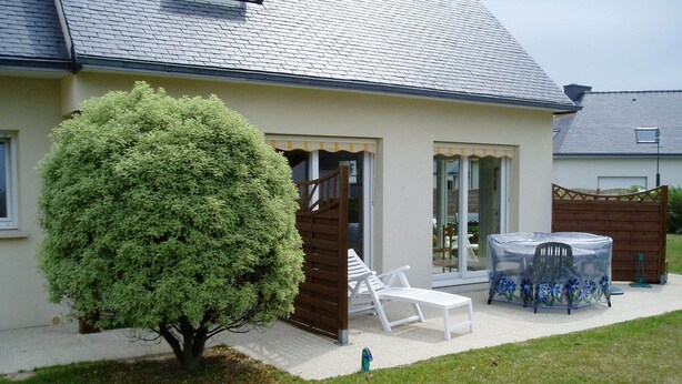 A house with a covered patio area, a small tree, and outdoor furniture. - Propriété (Saint-Pierre-Quiberon)