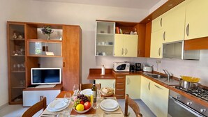 Cocina compacta con comedor, equipada con microondas, tostadora y cocina a gas.
