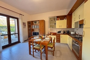 Una cocina compacta con una mesa de comedor, sillas y un televisor.